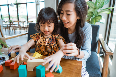 mother and kid playing with wooden blockの写真素材