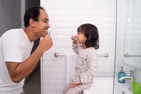 kid learn how to brush teeth with dadの写真素材