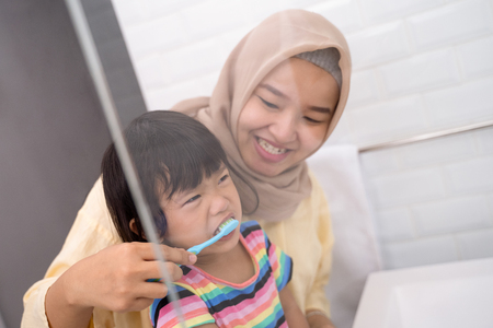 mother and her daughter brushing teethの写真素材