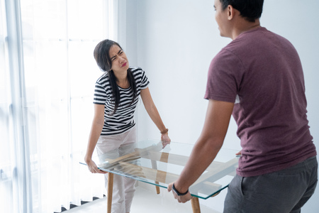 a new couple brings a table and his wife felt too heavy to lift furnitureの写真素材