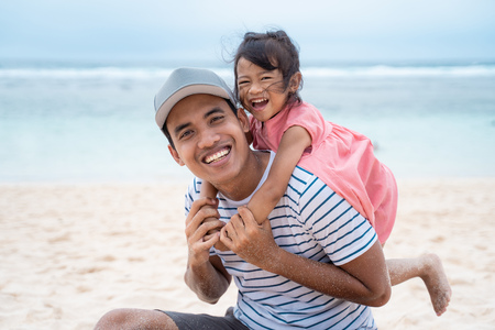 daughter embracing his father from behind when playingの写真素材
