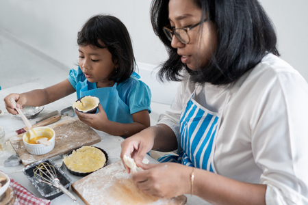 mother and kid learning to make some doughの写真素材