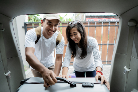 couple put suitcases in to the car trunkの写真素材