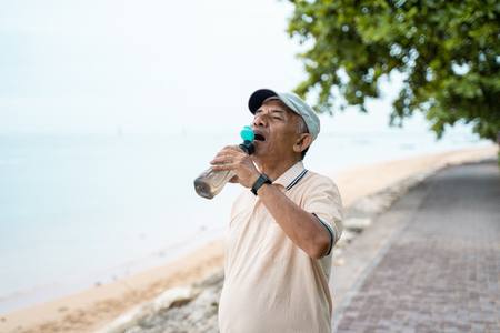 senior male asian drinking water bottleの写真素材