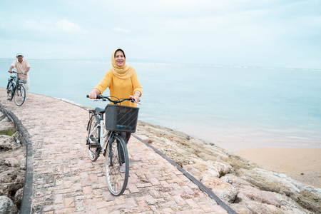 muslim woman with scarf riding a bikeの写真素材
