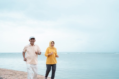 muslim old couple workout and running at the beachの写真素材