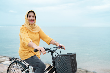 muslim woman with scarf riding a bikeの写真素材