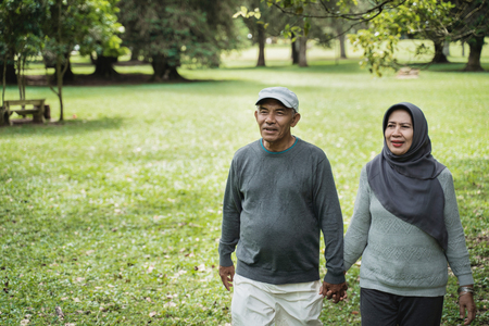 asian senior couple walking in the park and hold handの写真素材