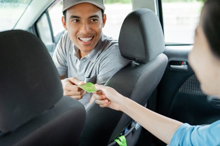 Asian young drivers kindly approve payment by credit cardの写真素材