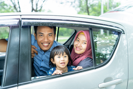 picture of family members inside a car sitting on seat back and look at cameraの写真素材