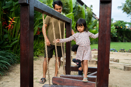 an older sister walked in front a little sister when playing balance beamの写真素材