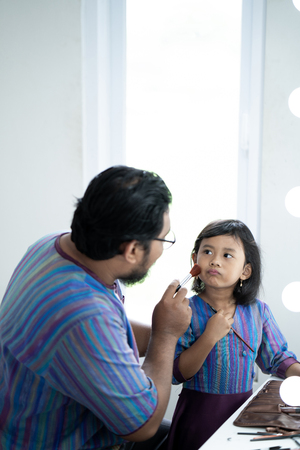 daddy and daughter play with make upの写真素材