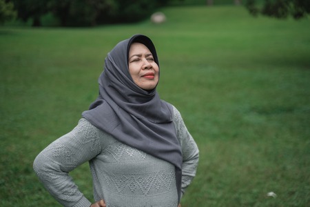 enior muslim woman relaxing taking deep breath and stretchingの写真素材