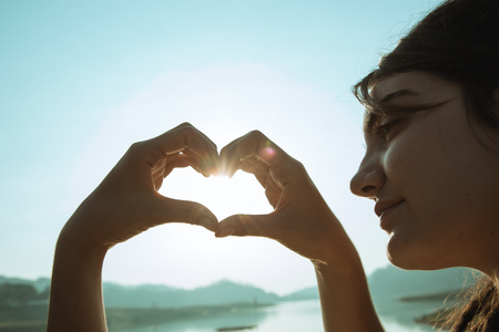 woman make a hearth shape in the morningの写真素材