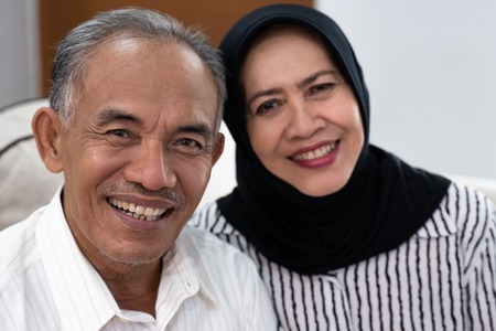 asian senior muslim couple looking at camera