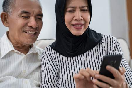 mature asian couple using smartphoneの写真素材