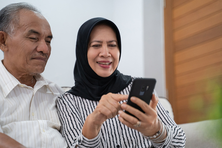 mature asian woman and man using cellphoneの写真素材
