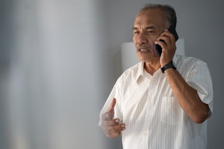 a experienced businessman talking by phone using a smartphone to two way communicationの写真素材