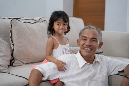 grandfather and his granddaughter in livingroom at home