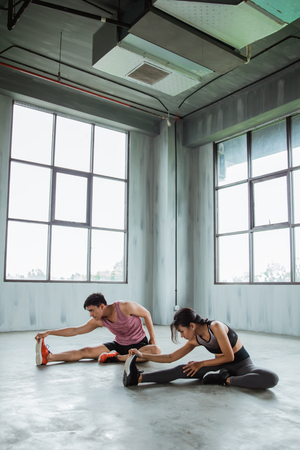 couple is stretching their legs togetherの写真素材