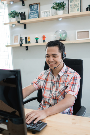 asian tele marketing on duty talk via phoneの写真素材