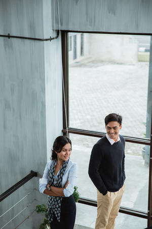 business people smile standing on the stairs with folded handsの写真素材