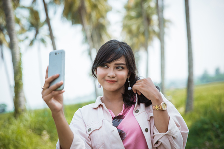 asian young woman take selfie of her self in hot summer dayの写真素材
