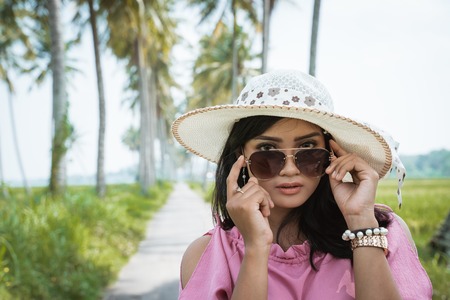 asian woman with sunglasses and hatの写真素材