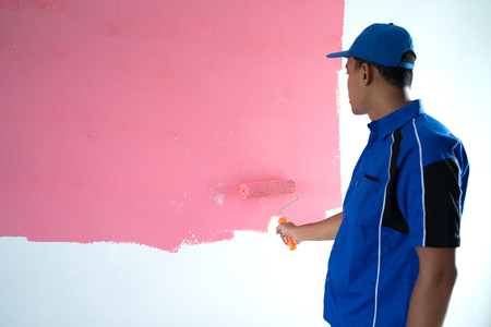 young worker painting on the wallの写真素材