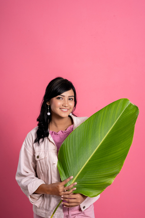 asian woman holding green leaf summer conceptの写真素材