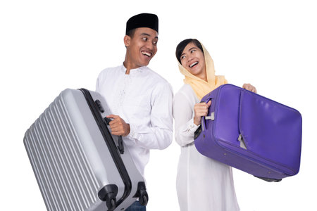 excited muslim couple with suitcase on white background