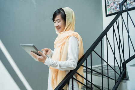muslim woman wearing hijab using tablet pcの写真素材