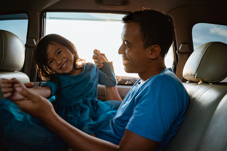asian daughter with father in the car playingの写真素材