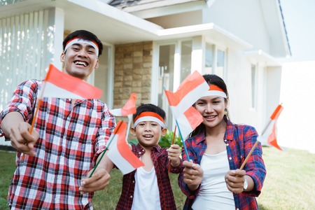 family holding a flag of indonesia. celebrating independence