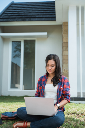 portrait of female asian student using laptop in the parkの写真素材