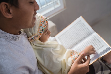 muslim father read quran with his daughterの写真素材