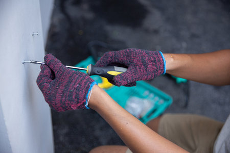 hands with gloves using screwdriverの写真素材