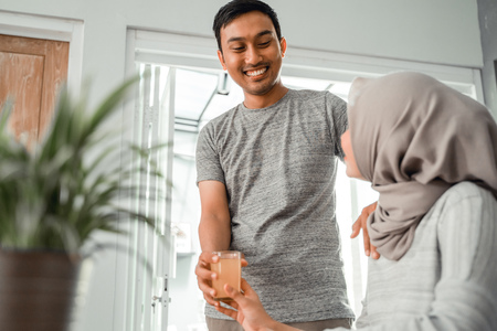 husband giving drink to his wifeの写真素材