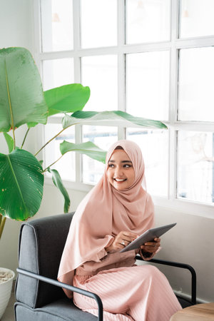 muslim woman browsing with tablet while relaxing
