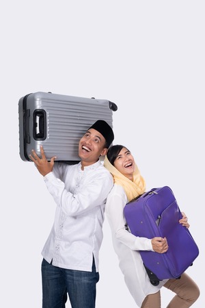 excited muslim couple with suitcase on white backgroundの写真素材