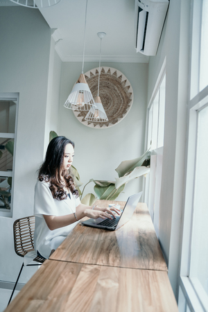 asian woman enjoy while working herself in cafeの写真素材