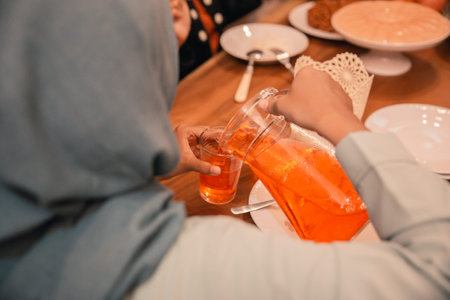 Hijab woman pours sweet drink in to a glass to break their fast