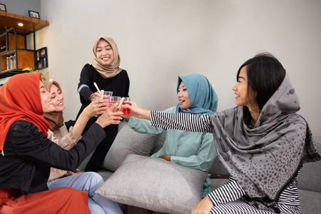 Veiled women drink cheers when breaking their fastの写真素材