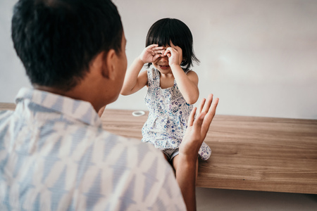 man mad at her daughter while working in home officeの写真素材
