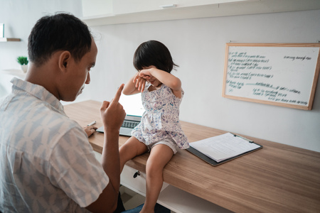 father is angry when his daughter interrupts himの写真素材