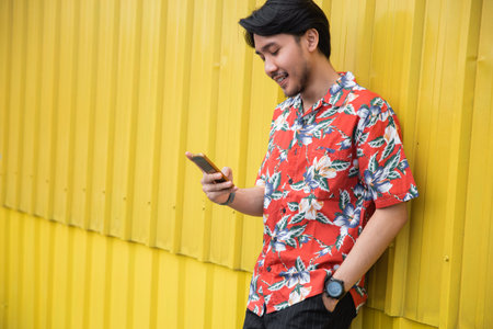 Young man standing front yellow background