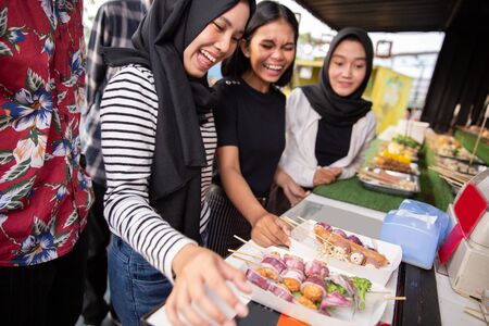 group of young women at a street food restaurantの写真素材