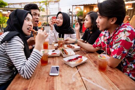 Young people lunch together on the outdoor foodcourtの写真素材