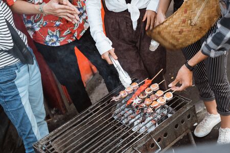 grilling food with skewers on charcoalの写真素材