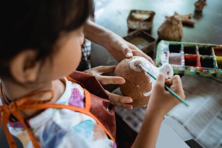 mother and daughter painting ceramic potの写真素材